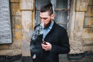 A guy using a vpe from a vape shop